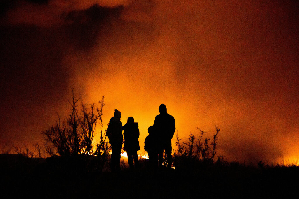 Silhouettes of a family against a fire