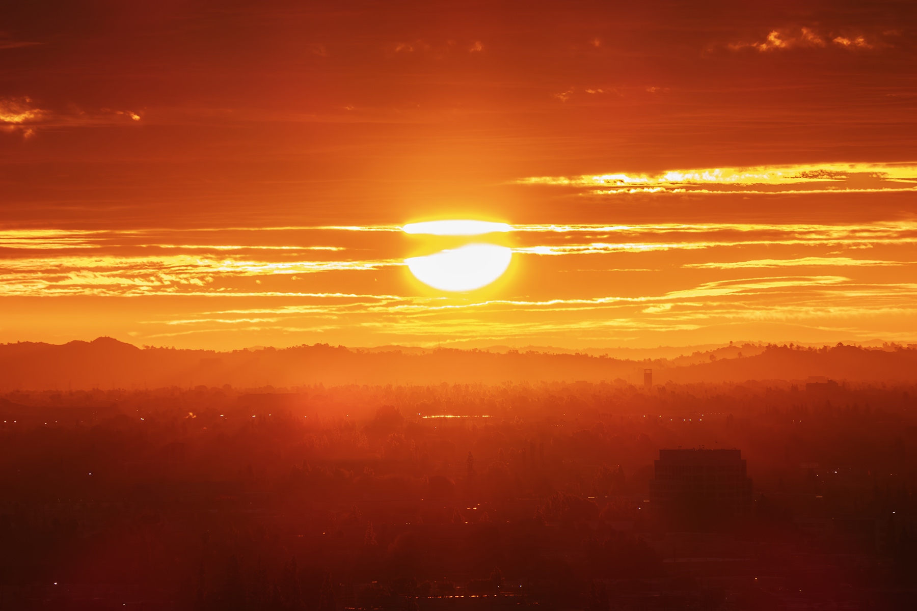 Los Angeles fiery morning sun bursting through clouds and fog above the San Fernando Valley.